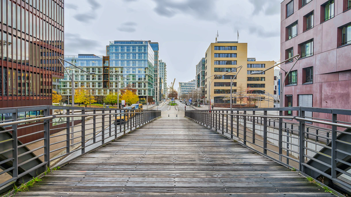 Wooden bridge leading to modern buildings near Elbphilharmonie, Hamburg.