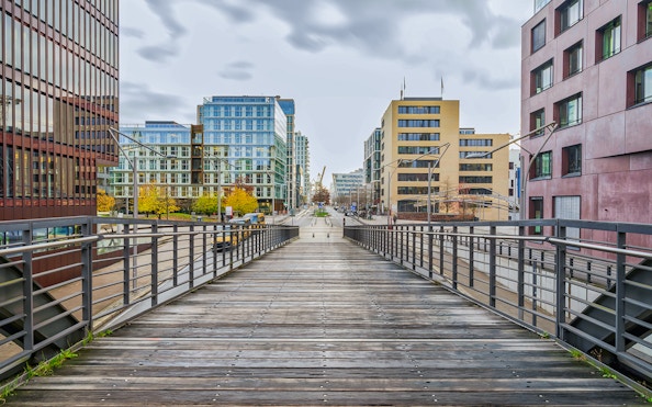Wooden bridge leading to modern buildings near Elbphilharmonie, Hamburg.