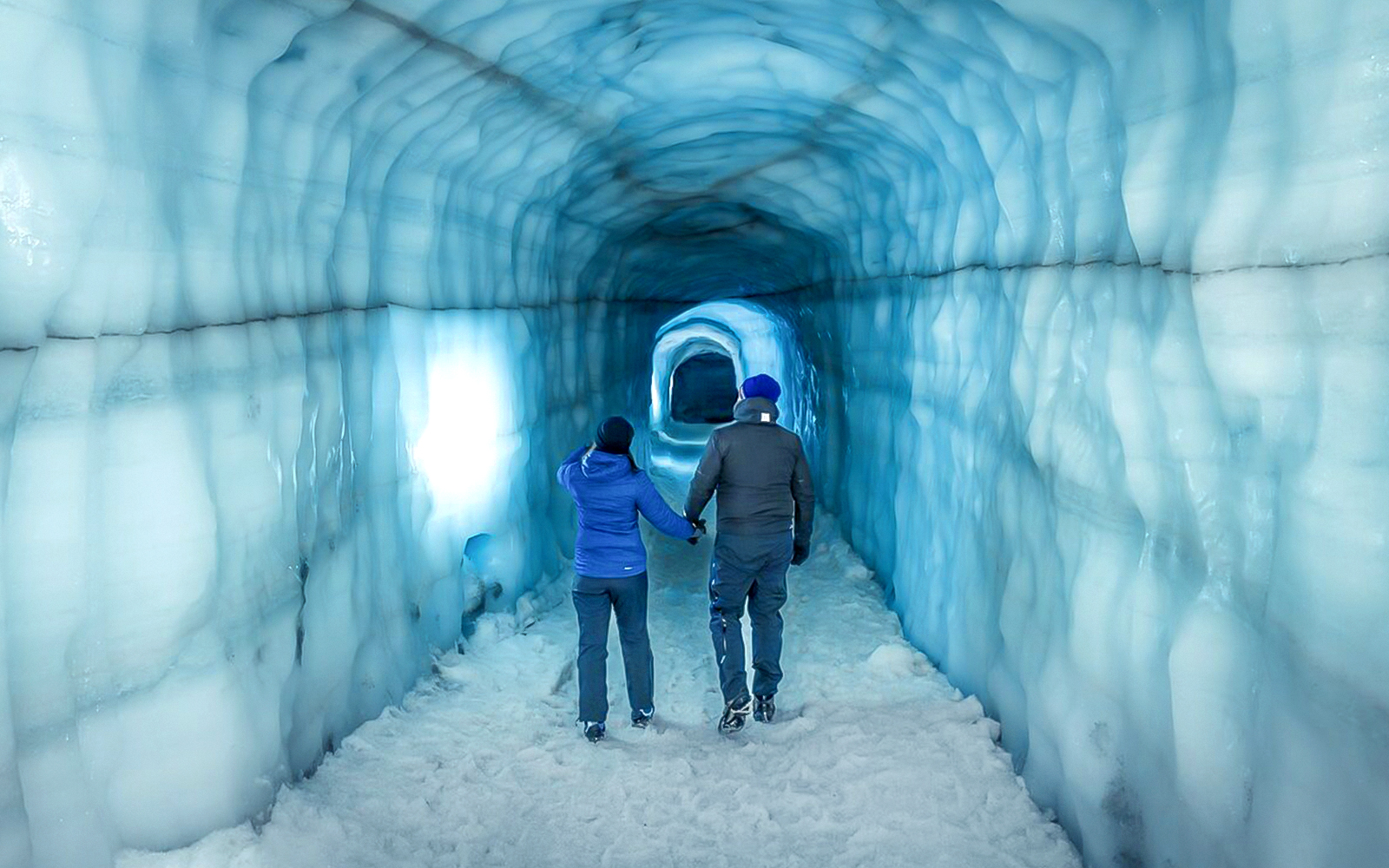 Guests walking inside the blue ice tunnel of Langjökull glacier.
