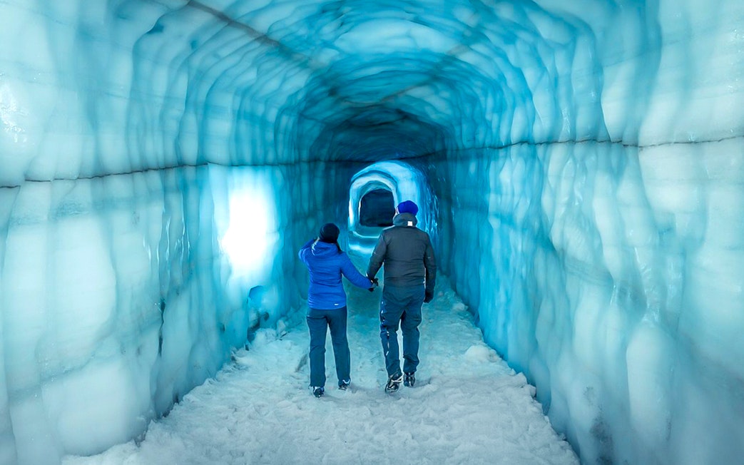 Guests walking inside the blue ice tunnel of Langjökull glacier.