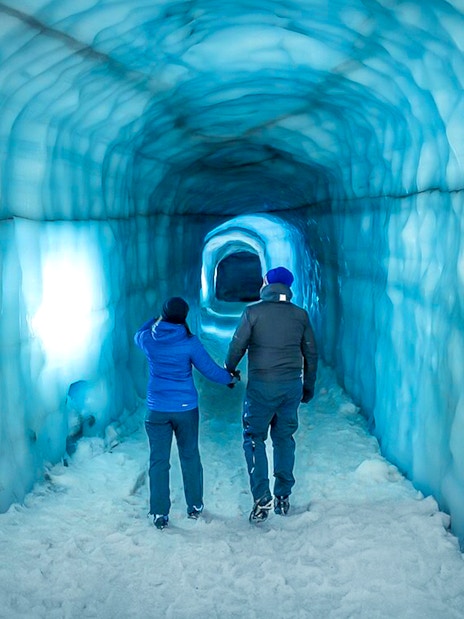 Guests walking inside the blue ice tunnel of Langjökull glacier.