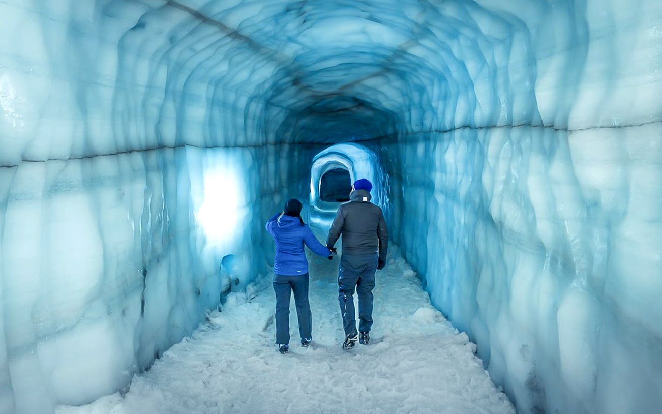 Guests walking inside the blue ice tunnel of Langjökull glacier.
