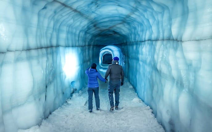 Guests walking inside the blue ice tunnel of Langjökull glacier.