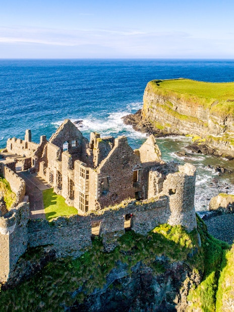 Dunluce Castle ruins on a coastal cliff in Northern Ireland with ocean view.