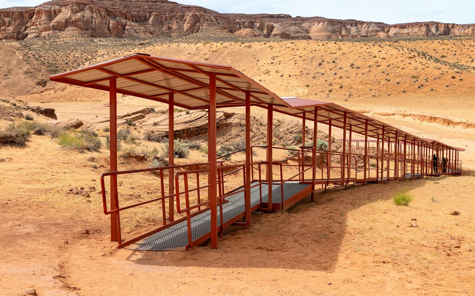 Walkway leading to Upper Antelope Canyon with desert landscape in Arizona.