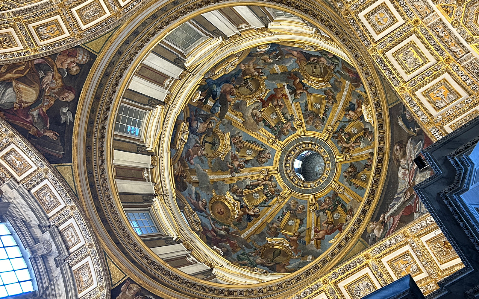 St. Peter's Basilica dome interior with intricate frescoes and gold detailing, Vatican City.