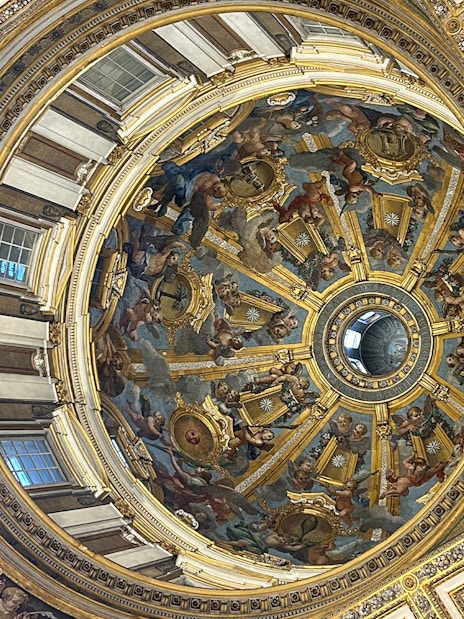 St. Peter's Basilica dome interior with intricate frescoes and gold detailing, Vatican City.