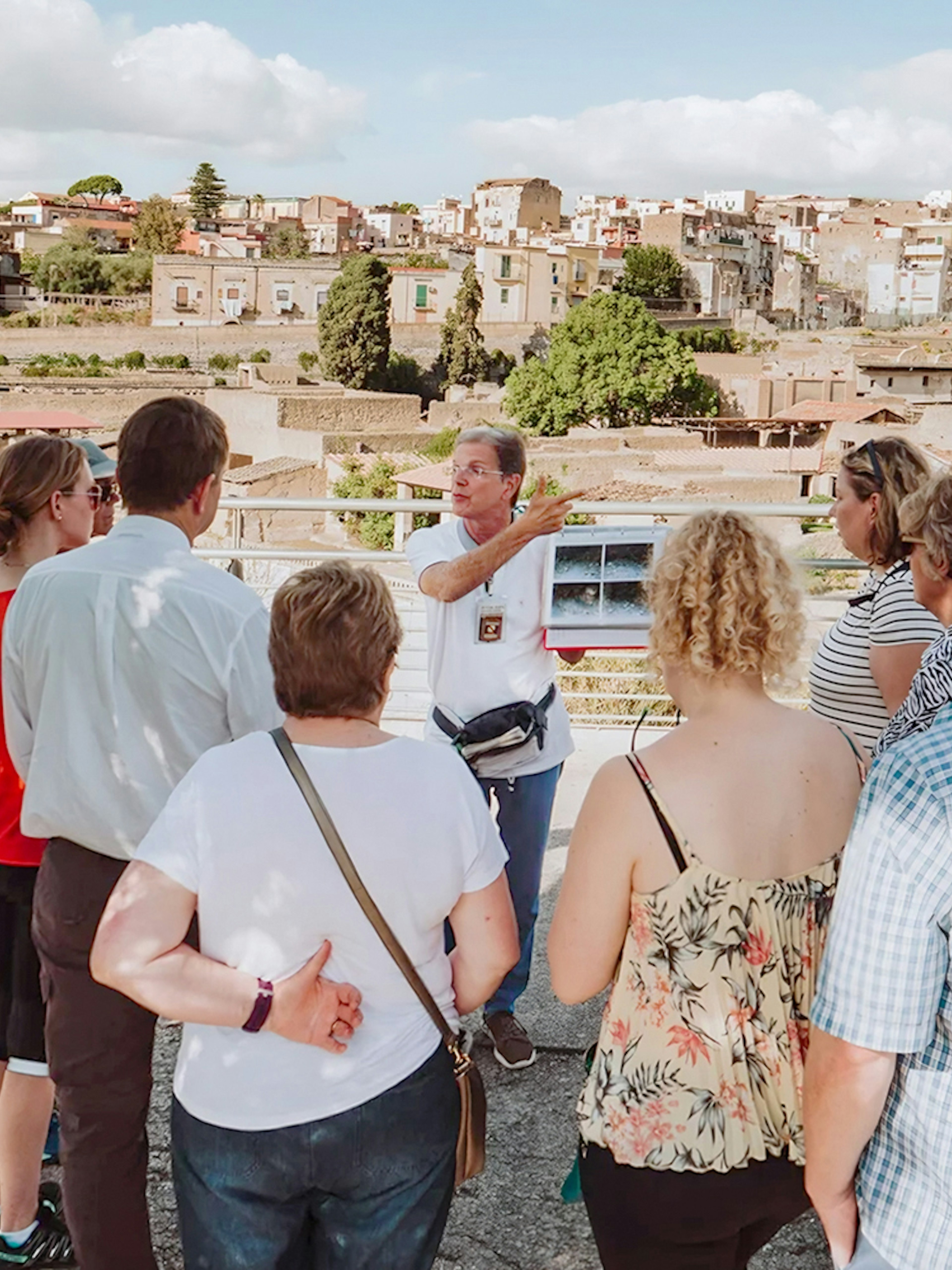 Archaeologist explaining Herculaneum ruins to tourists in Naples, Italy.
