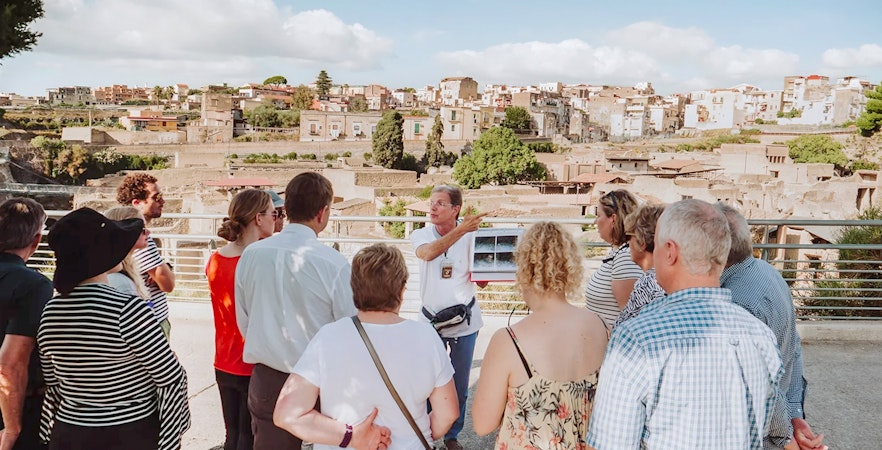 Archaeologist explaining Herculaneum ruins to tourists in Naples, Italy.