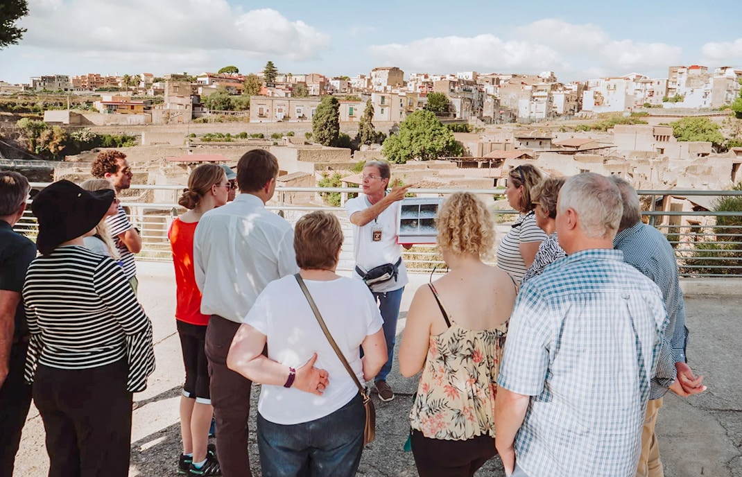 Archaeologist explaining Herculaneum ruins to tourists in Naples, Italy.
