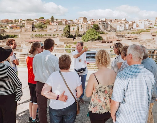 Archaeologist explaining Herculaneum ruins to tourists in Naples, Italy.