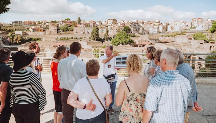 Archaeologist explaining Herculaneum ruins to tourists in Naples, Italy.