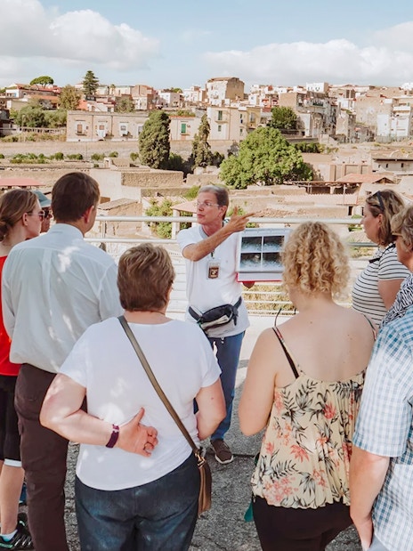 Archaeologist explaining Herculaneum ruins to tourists in Naples, Italy.