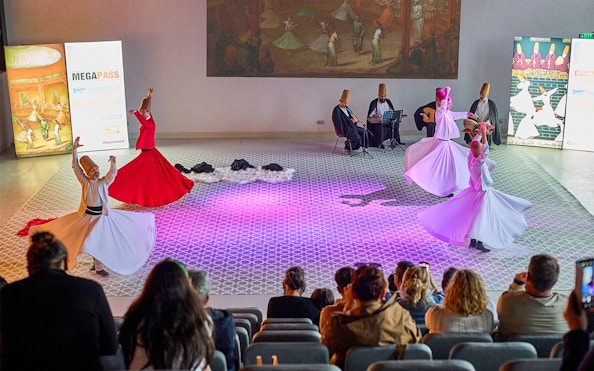 Whirling Dervishes performing in Istanbul with musicians in the background.