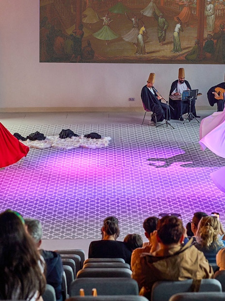 Whirling Dervishes performing in Istanbul with musicians in the background.