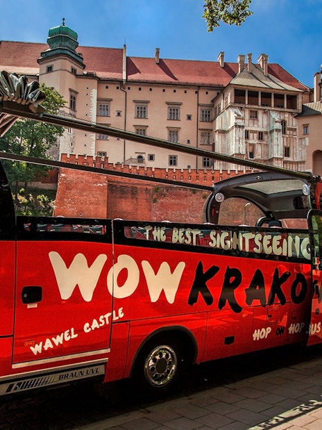 Kraków hop-on hop-off bus near Wawel Castle with tourists boarding.