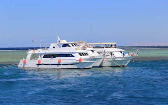 Motor yachts anchored in the Red Sea, Hurghada, with passengers on deck.