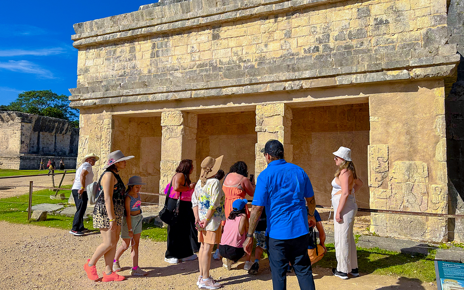 Tourists exploring ancient structures at Chichen Itza during sunrise.