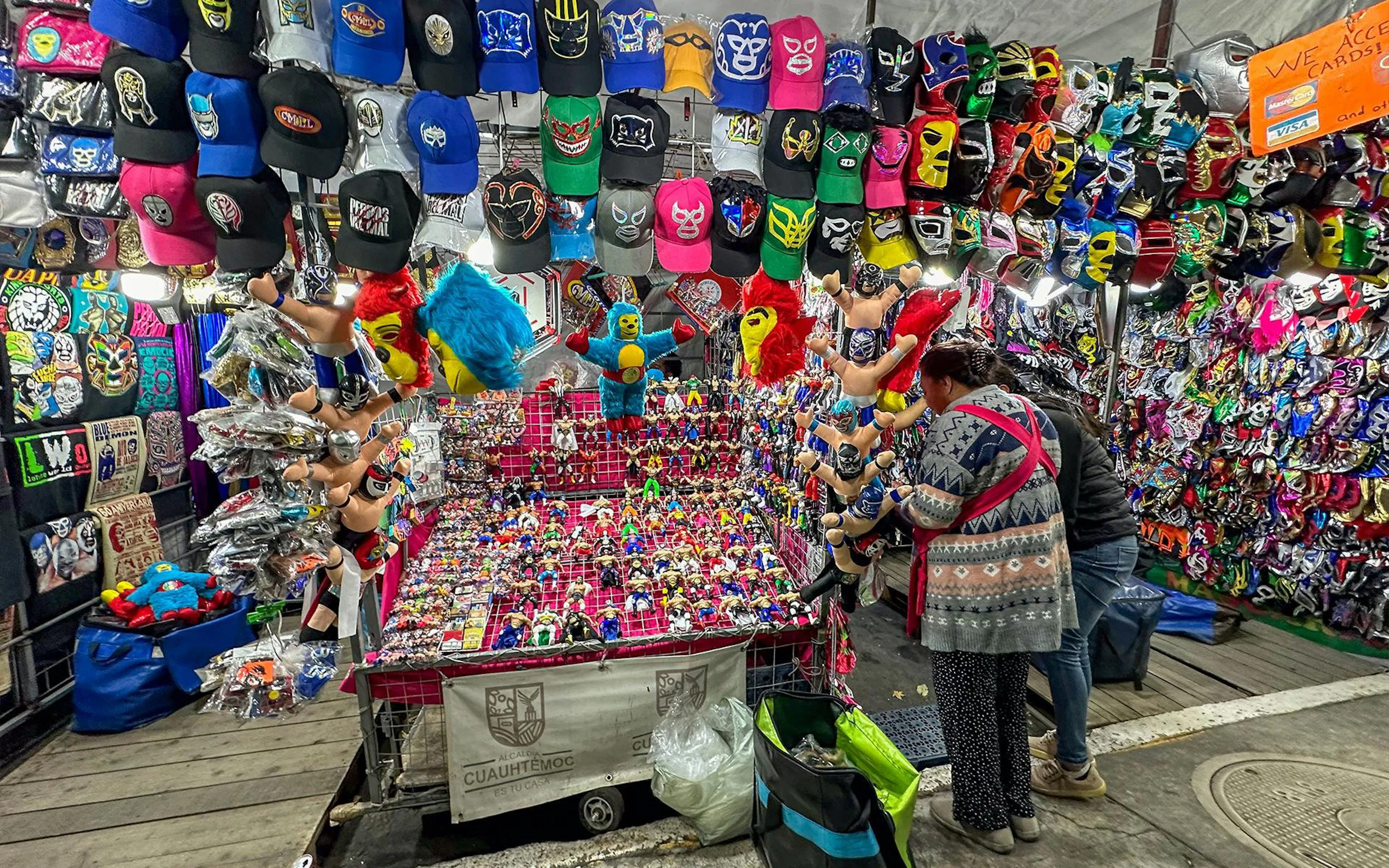 Lucha Libre merchandise stall with masks and toys at Arena Mexico.