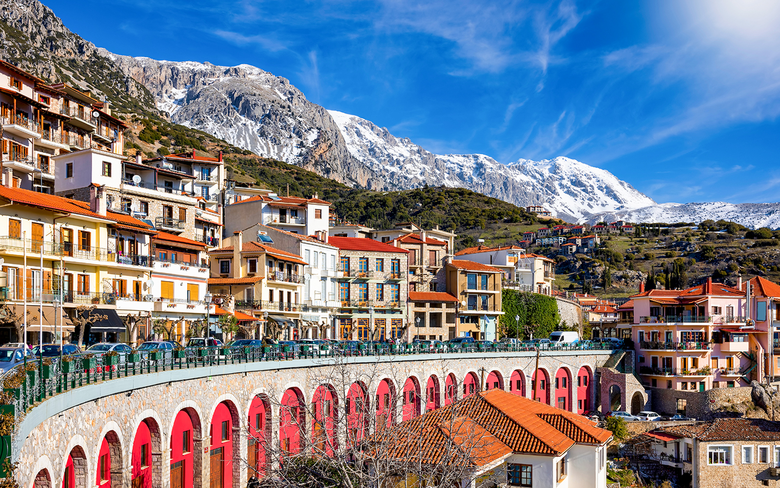 Arachova town with colorful buildings and snow-capped mountains in the background.