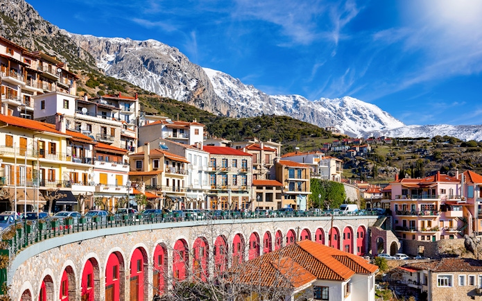 Arachova town with colorful buildings and snow-capped mountains in the background.