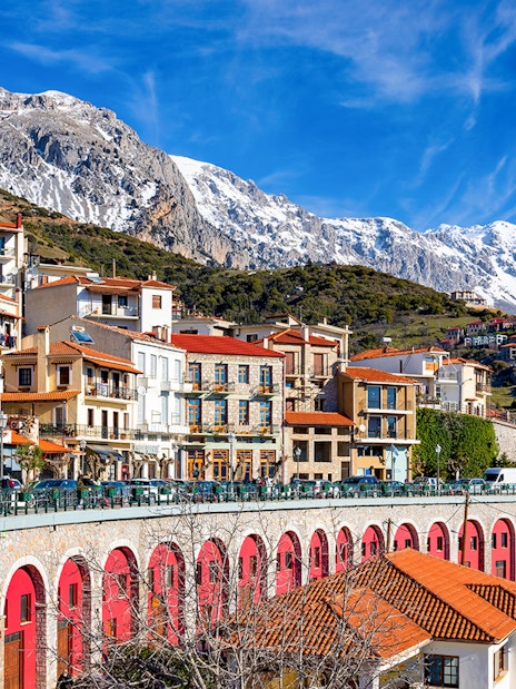 Arachova town with colorful buildings and snow-capped mountains in the background.