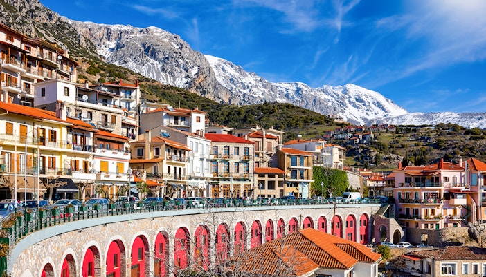 Arachova town with colorful buildings and snow-capped mountains in the background.