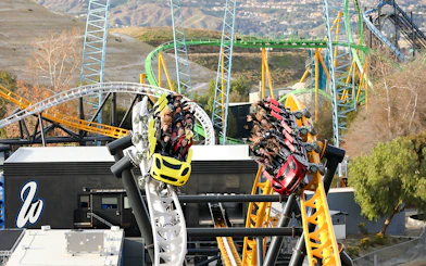 Roller coasters racing at Six Flags Magic Mountain's West Coast Racers with riders enjoying the thrill.
