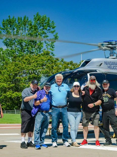 Group of tourists posing in front of a Niagara Helicopters aircraft in Canada.