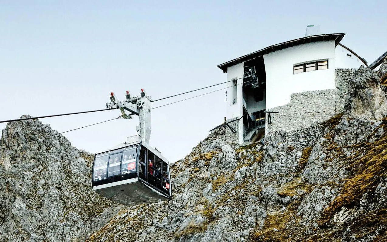 Cable car ascending rocky mountain to station at Top of Innsbruck.