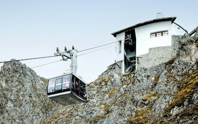 Cable car ascending rocky mountain to station at Top of Innsbruck.