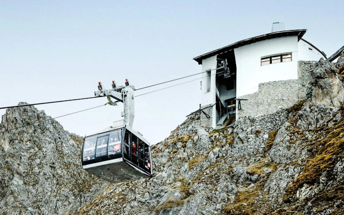 Cable car ascending rocky mountain to station at Top of Innsbruck.