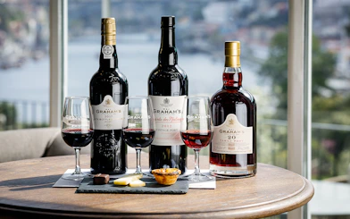 Graham's Port wine bottles and glasses with tastings at a table in Porto.