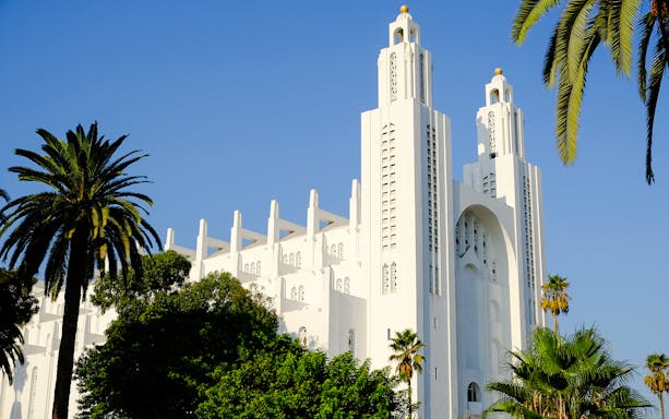 Casablanca Cathedral in Morocco with palm trees in the foreground.