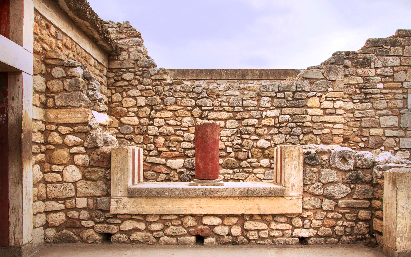 Knossos Palace stone wall with red column in Crete, Greece.