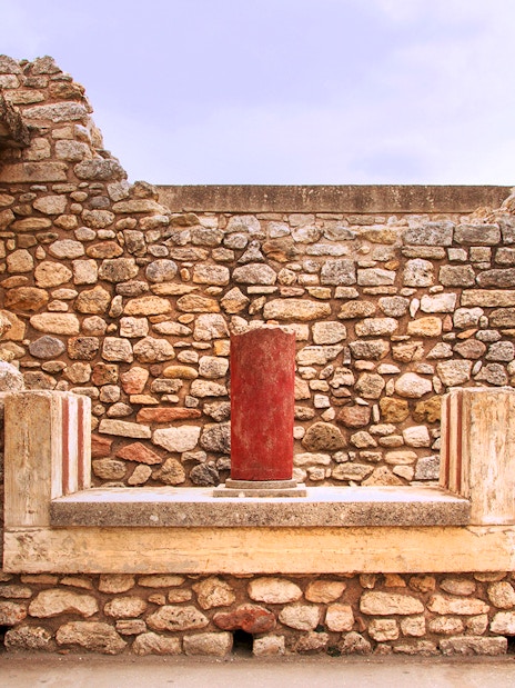 Knossos Palace stone wall with red column in Crete, Greece.