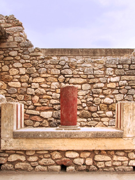 Knossos Palace stone wall with red column in Crete, Greece.