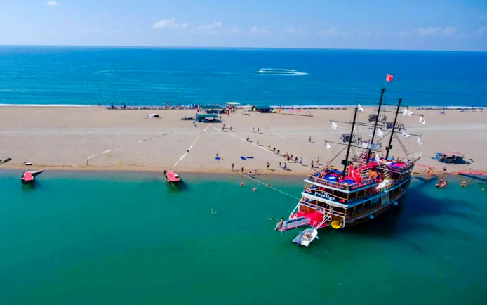 Cruise ship docked on sandy beach during Side Manavgat River Cruise tour.
