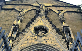 Facade of a historic church with detailed stone carvings in Naples, part of the self-guided city exploration game.