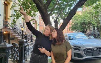 Two people exploring a tree-lined street in New York, part of a self-guided city exploration game.