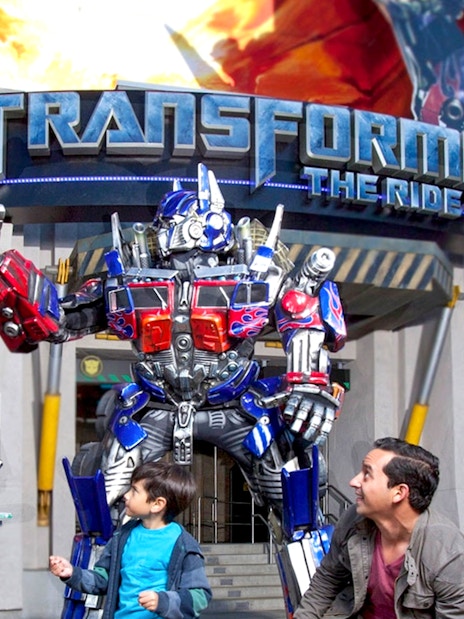 Transformers characters at Universal Studios Hollywood with visitors in front of the ride entrance.
