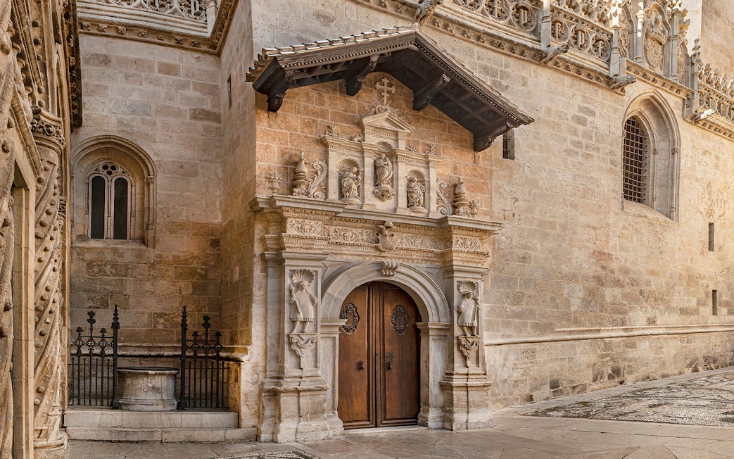 Entrance to the Royal Chapel of Granada, Spain, featuring ornate stone carvings and arched doorway.