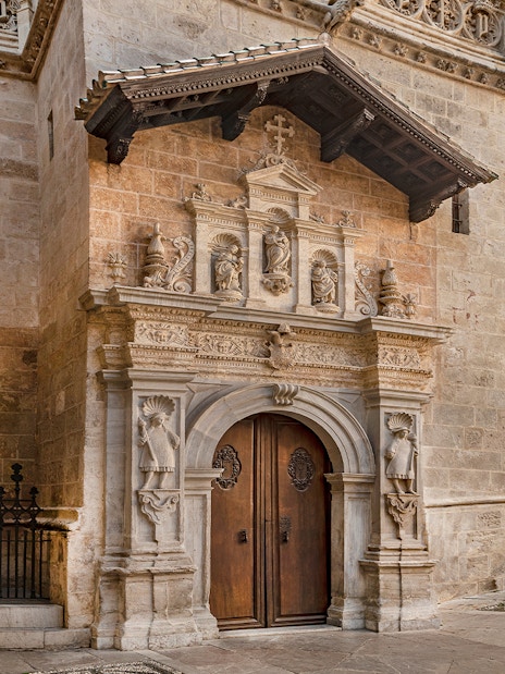 Entrance to the Royal Chapel of Granada, Spain, featuring ornate stone carvings and arched doorway.
