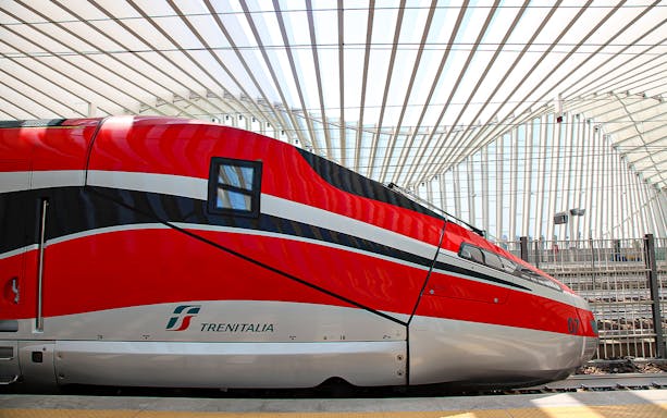 Frecciarossa train at a modern station platform in Italy.