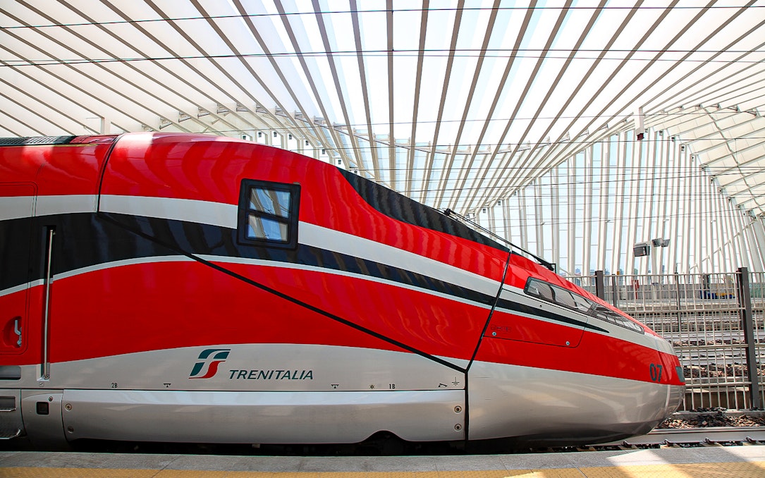 Trenitalia high-speed train at a modern station in Italy.