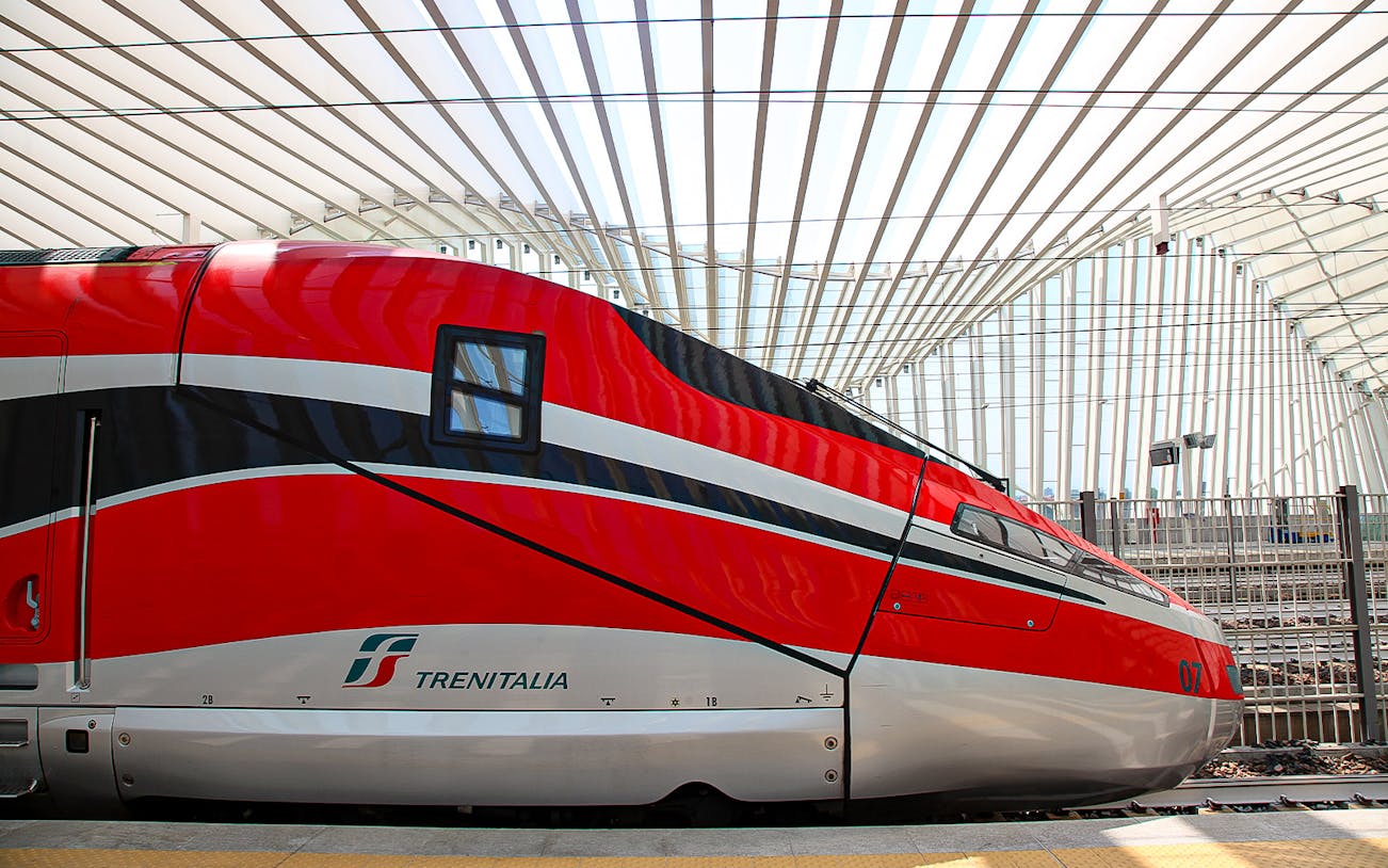 Trenitalia high-speed train at a modern station in Italy.