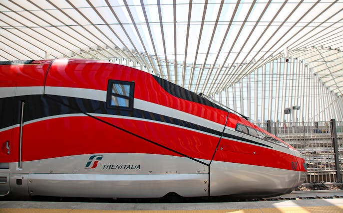 Trenitalia high-speed train at a modern station in Italy.