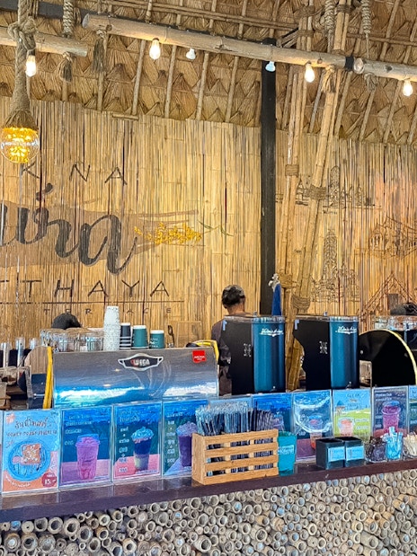 Cafe Rakna coffee counter with bamboo decor and menu displays in Ayutthaya.