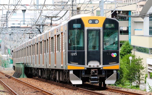 Kansai Railway train traveling on urban tracks in Japan.