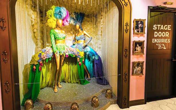 Broadway costume display with feathered headdresses at The Museum Of Broadway.